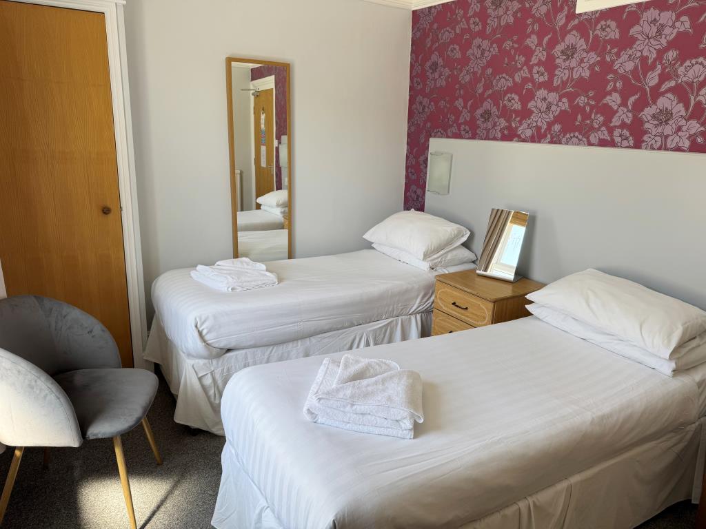 Lot: 48 - FREEHOLD CLIFF TOP HOTEL WITH TWENTY EN-SUITE GUEST ROOMS AND STUNNING VIEWS - A Twin bedroom on the First Floor